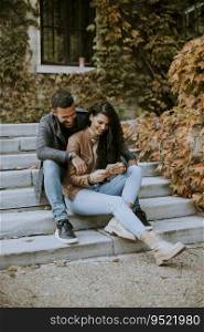 Handsome young couple sitting on outdoor stairs on a autumn day