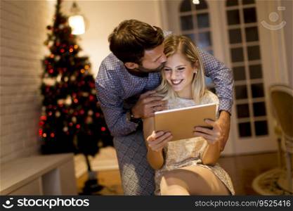 Handsome young couple with tablet at New Years eve at home