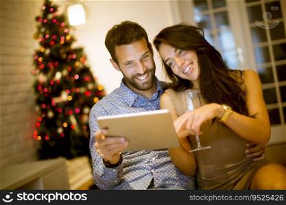 Handsome young couple with tablet at New Years eve at home