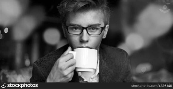 Handsome young guy drinking aromatic black coffee