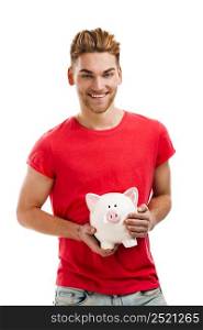 Handsome young holding a piggybank and smiling, isolated over a white background