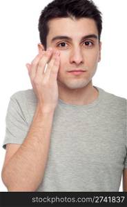 handsome young man applying eye cream for dark circles (isolated on white background)