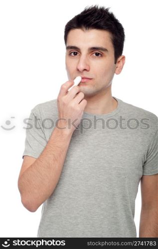 handsome young man applying lip balm (isolated on white background)