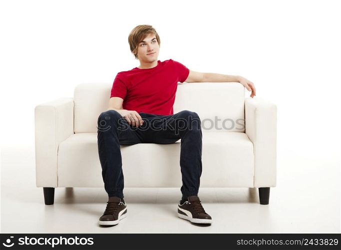 Handsome young man at home sitting on the couch