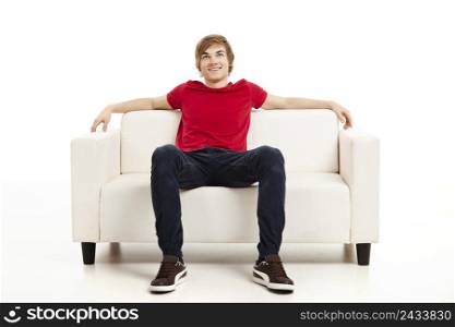 Handsome young man at home sitting on the couch