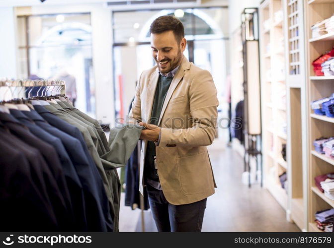 Handsome young man buying clothes in the store