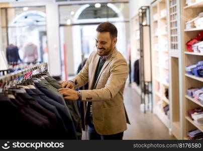 Handsome young man buying clothes in the store