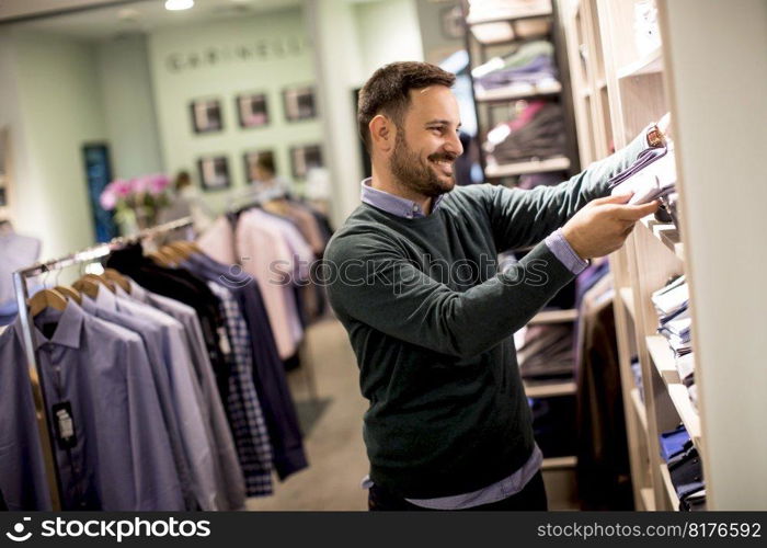 Handsome young man buying clothes in the store