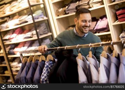 Handsome young man buying shirt in the store