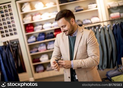 Handsome young man buying suit in the store