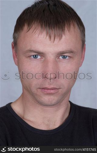 Handsome young man close up portrait on gray background