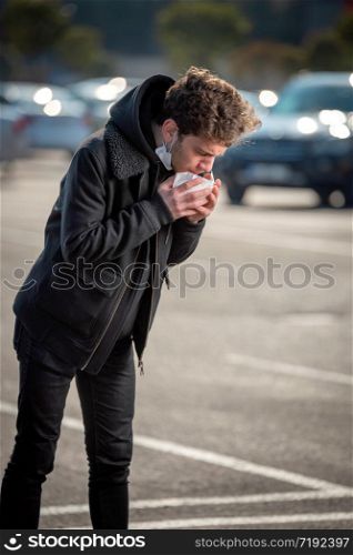 Handsome young man coughing because of flu or coronavirus