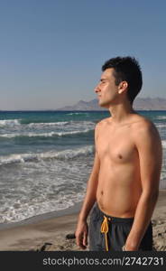 handsome young man getting suntan at Kos beach in Greece (blue sky)