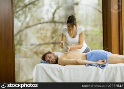 Handsome young man having relax massage in the spa