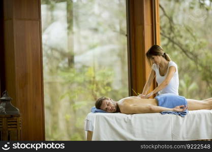 Handsome young man having relax massage in the spa