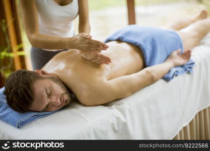 Handsome young man having relax massage in the spa
