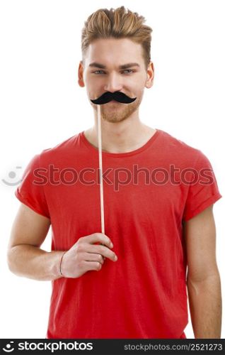 Handsome young man holding a fake moustache in front of his hace