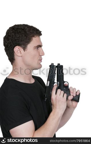 Handsome young man holding a hand gun pistol