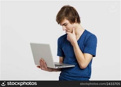 Handsome young man holding and working with a laptop, isolated over a white background