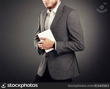 Handsome Young Man in Business Suit. Casual style and Electronic Gadgets. Smart Watches and Digital Tablet