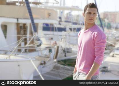 Handsome young man on summer in harbor, boats background