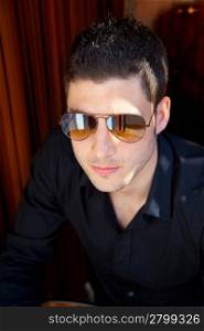 Handsome young man portrait with sunglasses and black shirt
