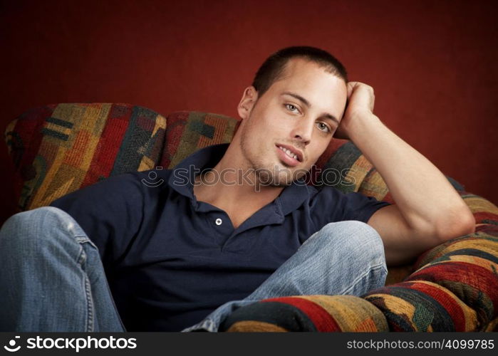 Handsome young man reclining in a colorful chair