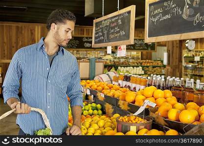 Handsome young man shopping for fruits in market