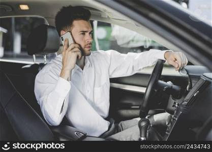 handsome young man sitting car talking mobile phone