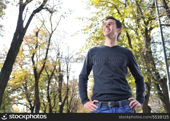 Handsome young man smiling outdoors in nature