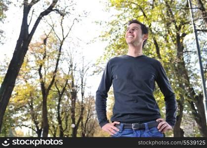 Handsome young man smiling outdoors in nature