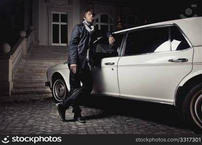 Handsome young man standing next to a limousine
