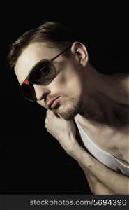 handsome young man unshaven wearing sunglasses with red heart on black background