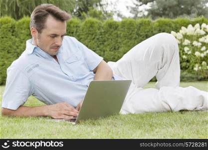 Handsome young man using laptop in park