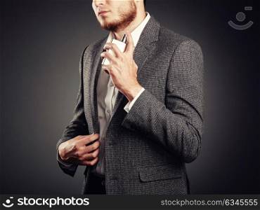Handsome Young Man using Perfume. Young Man in Business Suit. Casual Style