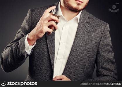 Handsome Young Man using Perfume. Young Man in Business Suit. Casual Style
