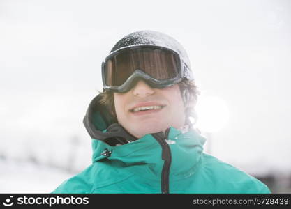 Handsome young man wearing ski goggles outdoors