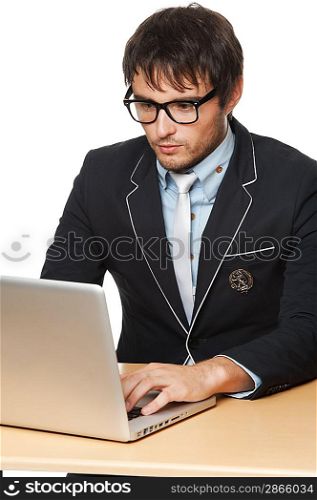 Handsome young man with a laptop behind desk.