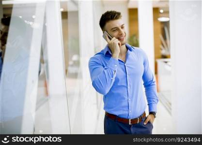 Handsome young man with mobile phone in the office