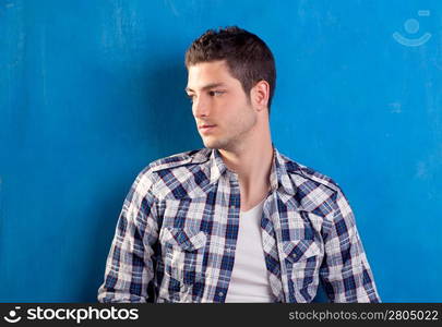 handsome young man with plaid shirt on blue background