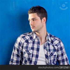 handsome young man with plaid shirt on blue background