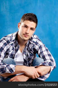 handsome young man with plaid shirt on blue background