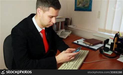 handsome young man with red tie, looking for meetings in calendar on his phone