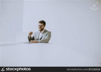 Handsome young man working on laptop in bright office