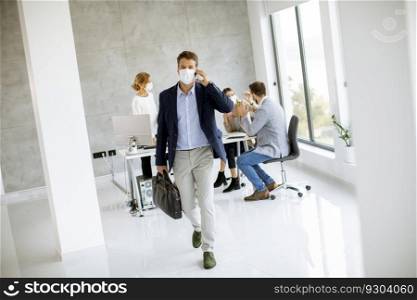 Handsome young mancouple walking and using mobile phone while wear protective masks to prevent corona viruus at office space