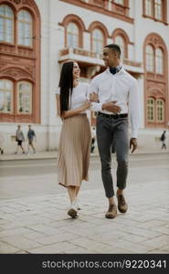 Handsome young multiethnic couple walking on the street