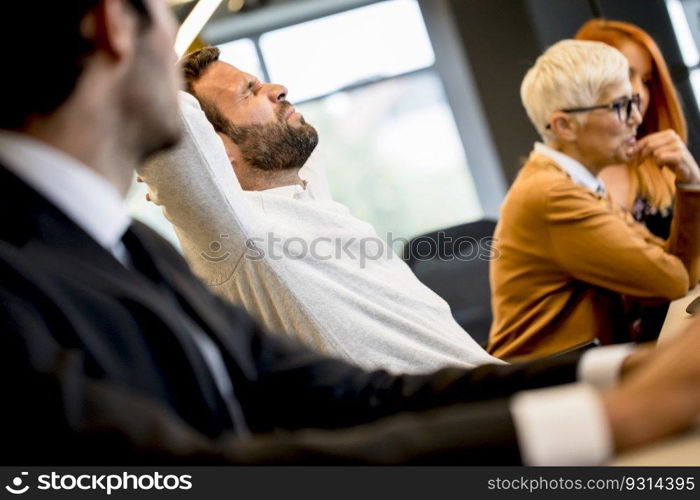 Handsome young professional businessman under stress uses a computer for work in the modern office