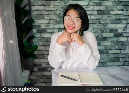 Handsome young smiling businesswoman working at home with laptop on desk