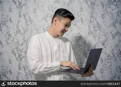 Handsome young smiling is holding a notebook and smiling at office