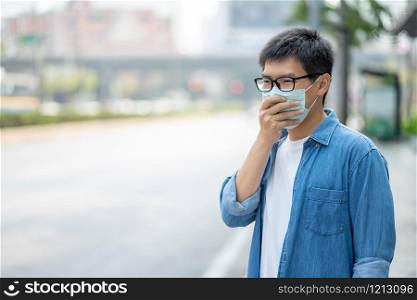 HandsomeMan wearing face mask protect filter against air pollution (PM2.5) or wear N95 mask. protect pollution, anti smog and viruses, Air pollution caused health problem. Global warming concept.